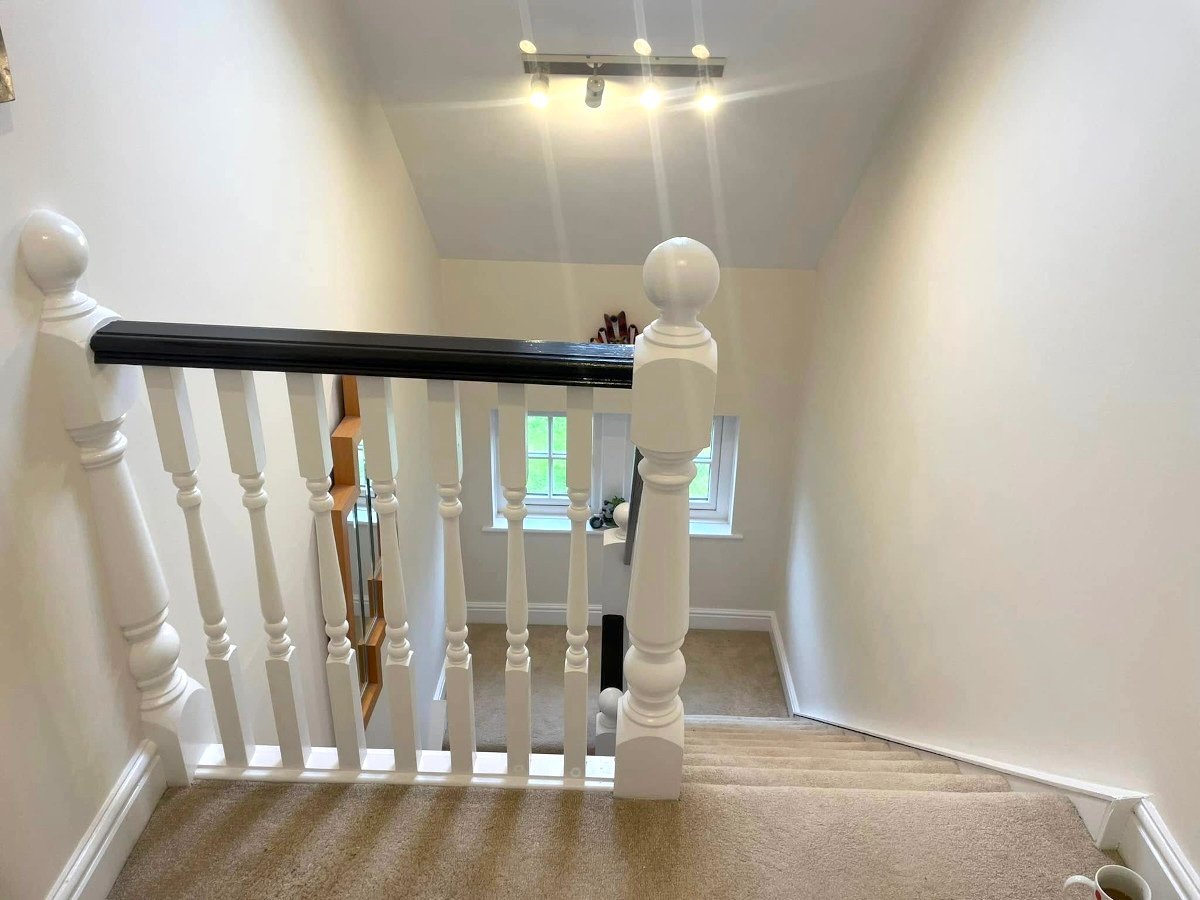 landing cream painted walls white banister black handrail newport orchid decor